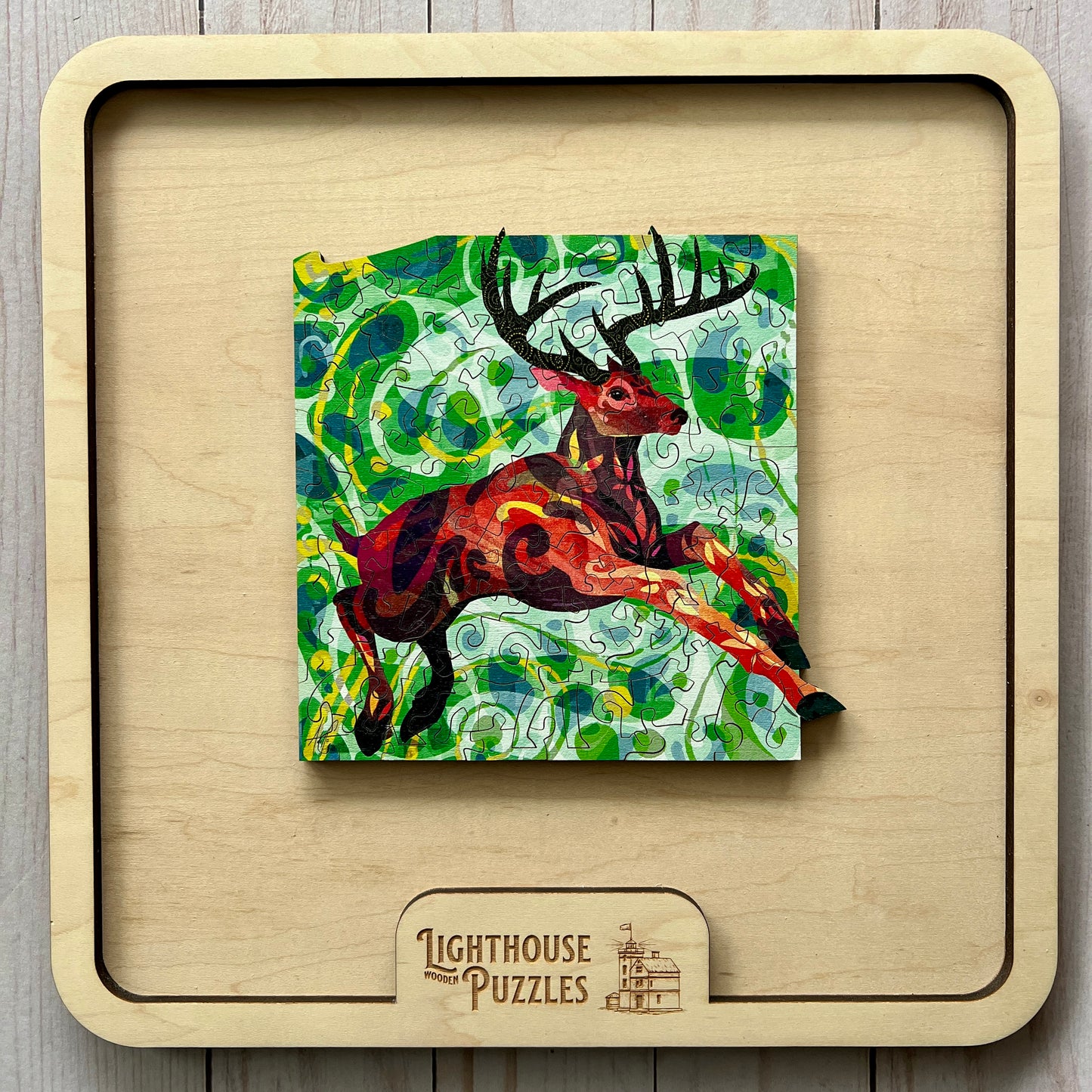 Whitetail deer wooden jigsaw puzzle displayed inside a wooden storage frame with Lighthouse Puzzles branding