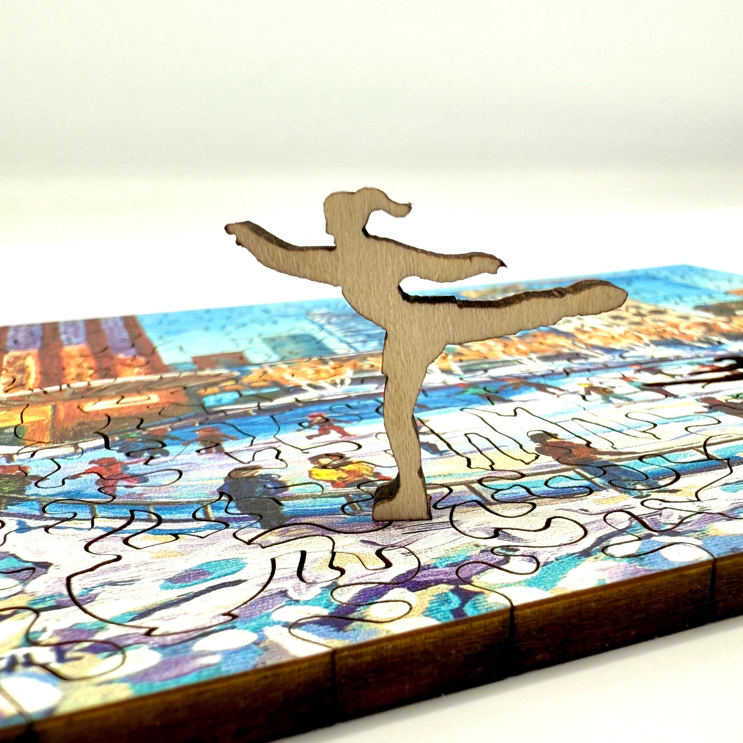 Close up of a wooden skating figure whimsy piece from the Downtown Ice Skating winter scene puzzle.