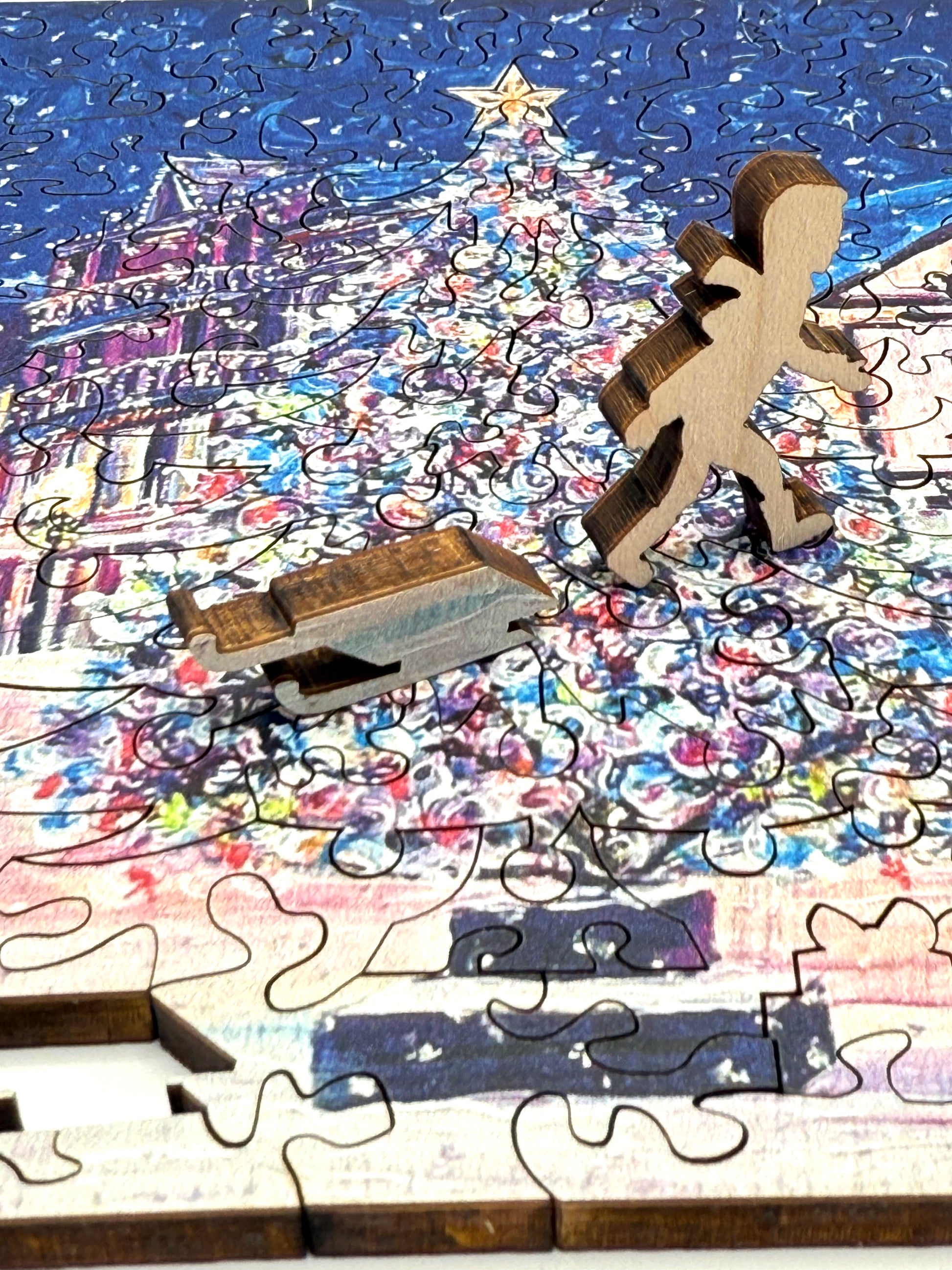 The Mackinac Christmas Tree wooden Christmas puzzle being assembled on a wooden table.