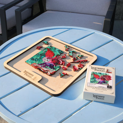 A wooden jigsaw puzzle partially assembled on a tray placed on a patio table on a sunny day.